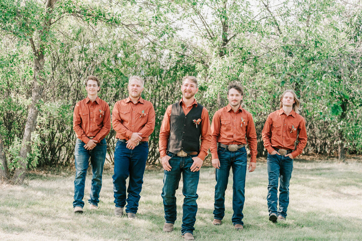 The groom and groomsmen walking  on the farm. 