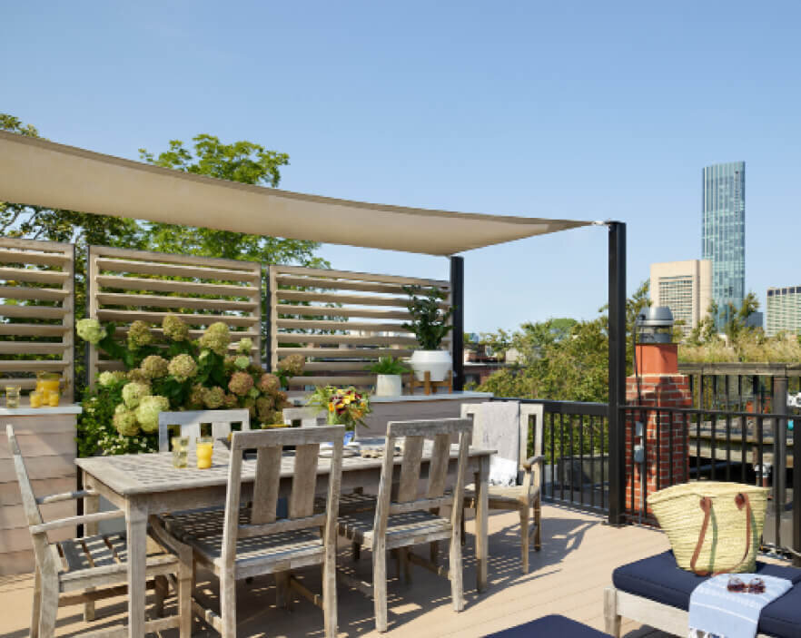 Brownstone Designer designed a roof deck in the South End with space for outdoor dining furniture and a custom sail cloth for shade.
