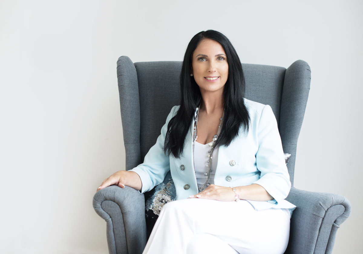 woman president executive  headshot sitting in chair  powerful  confident and  warm  person