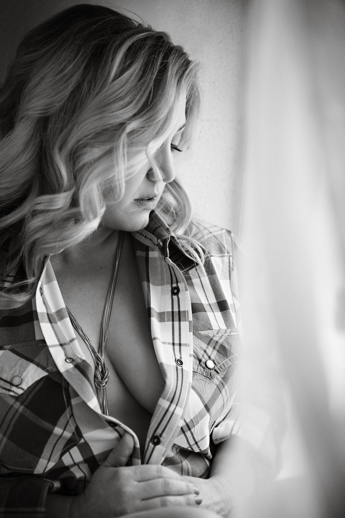Black and white of a woman in her boyfriend's shirt with her breasts partially exposed
