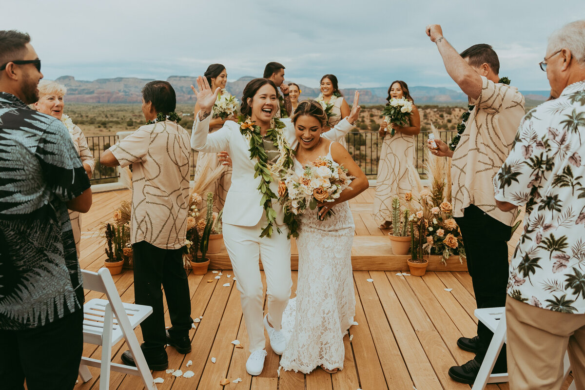 same sex couple walks down isle in sedona