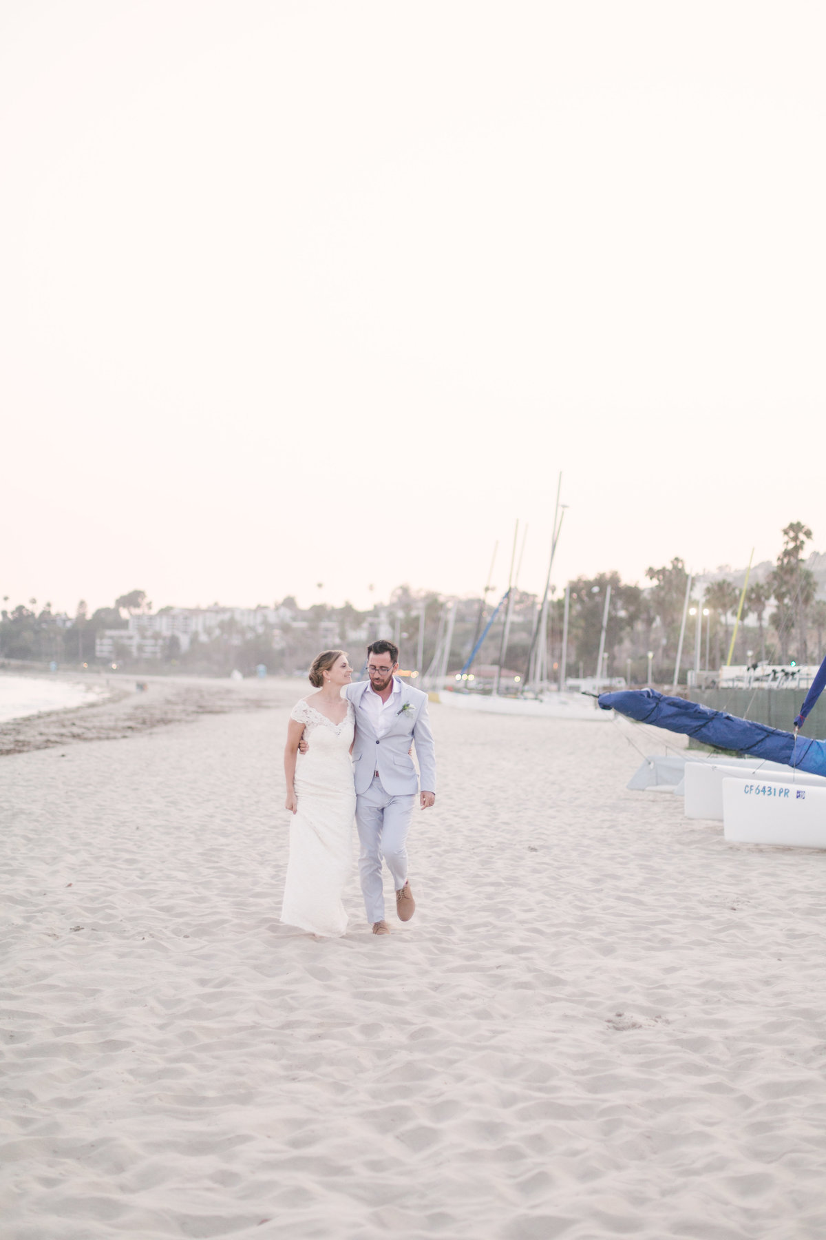 Bride and groom walk along coastline at Santa Barbara Yacht Club wedding