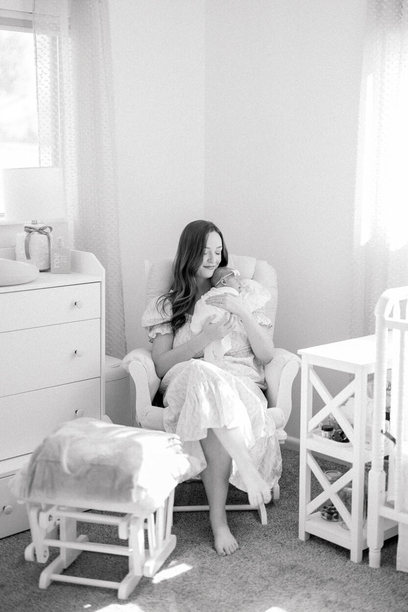 mom holding newborn in a rocking chair