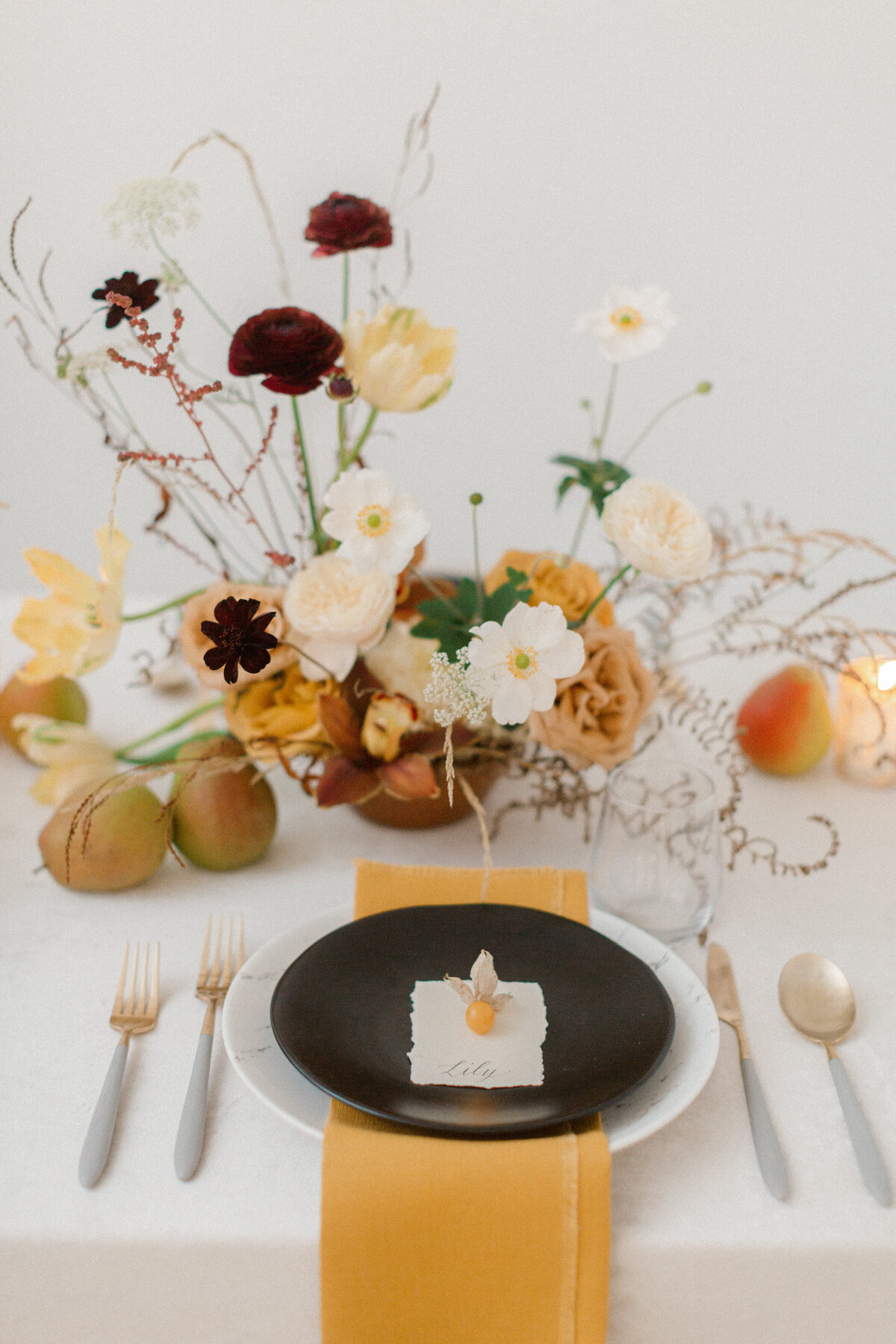 An airy garden centrepiece of yellow and orange flowers at a Montreal wedding reception. 