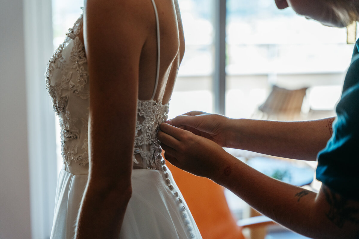 Bride’s mother adjusting wedding gown strap