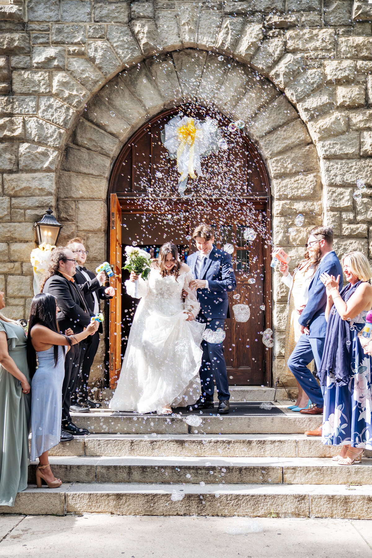 bride and groom leave Sacred Heart Cathedral with bubble exit in downtown Raleigh