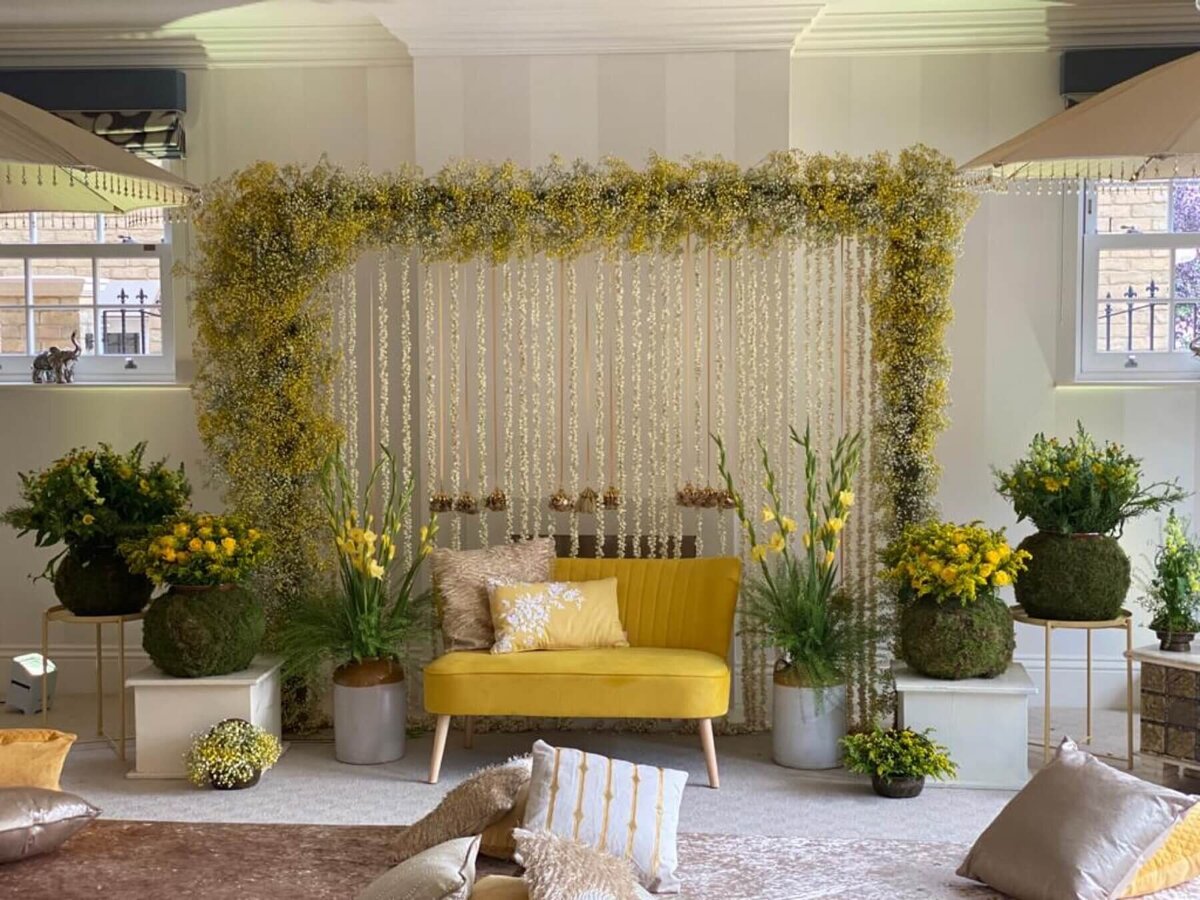 Yellow floral backdrop with garden flowers and sofa seating