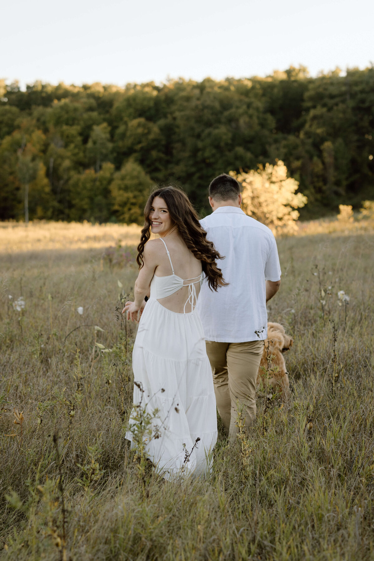 A couple running through a field during their engagement session