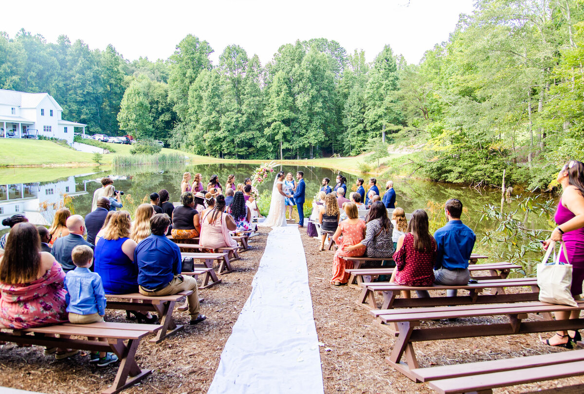 guests sitting and watching at an outdoor wedding ceremony