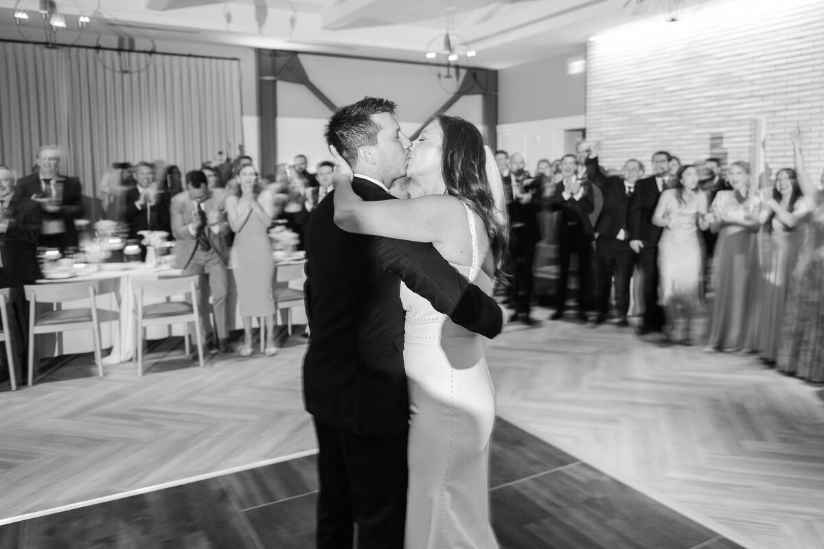 A timeless black-and-white shot of the bride and groom kissing during their first dance at Lido House in Newport Beach