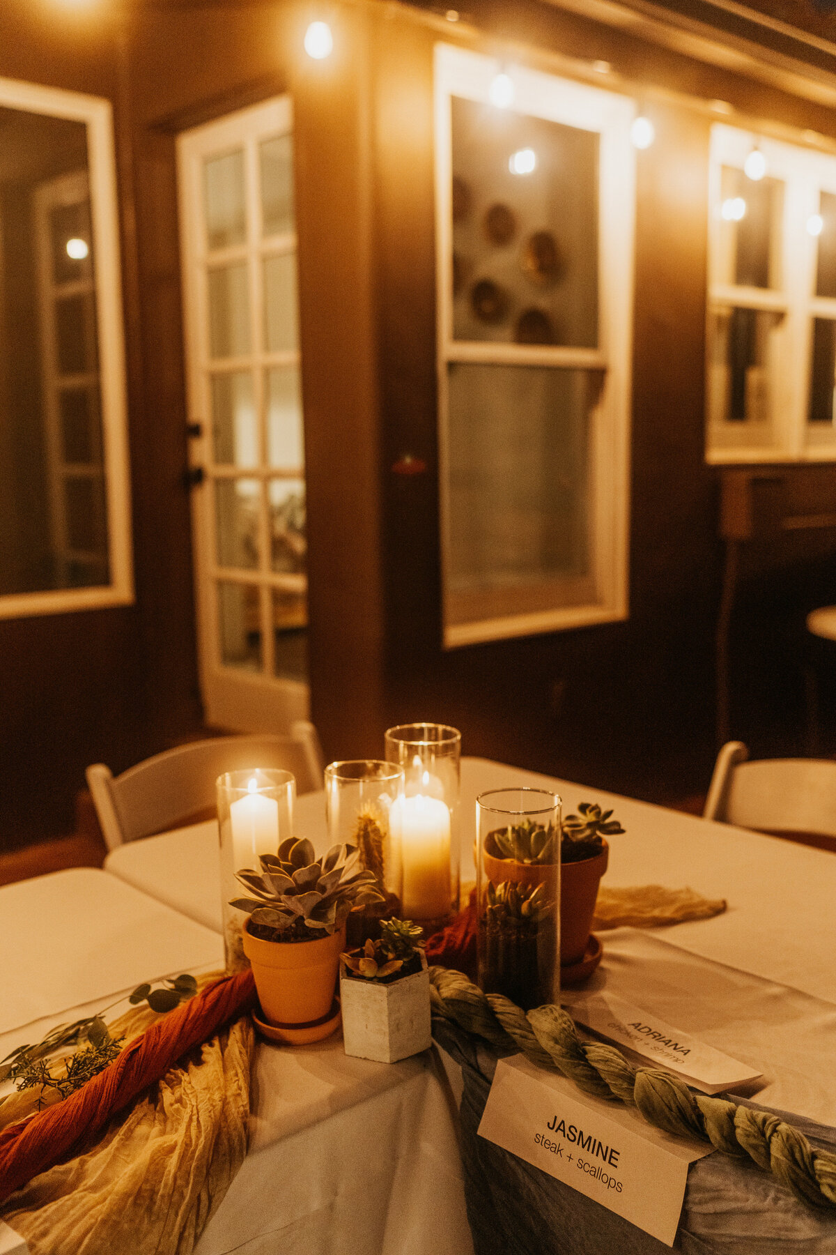 A small table with candles and succulents in the middle