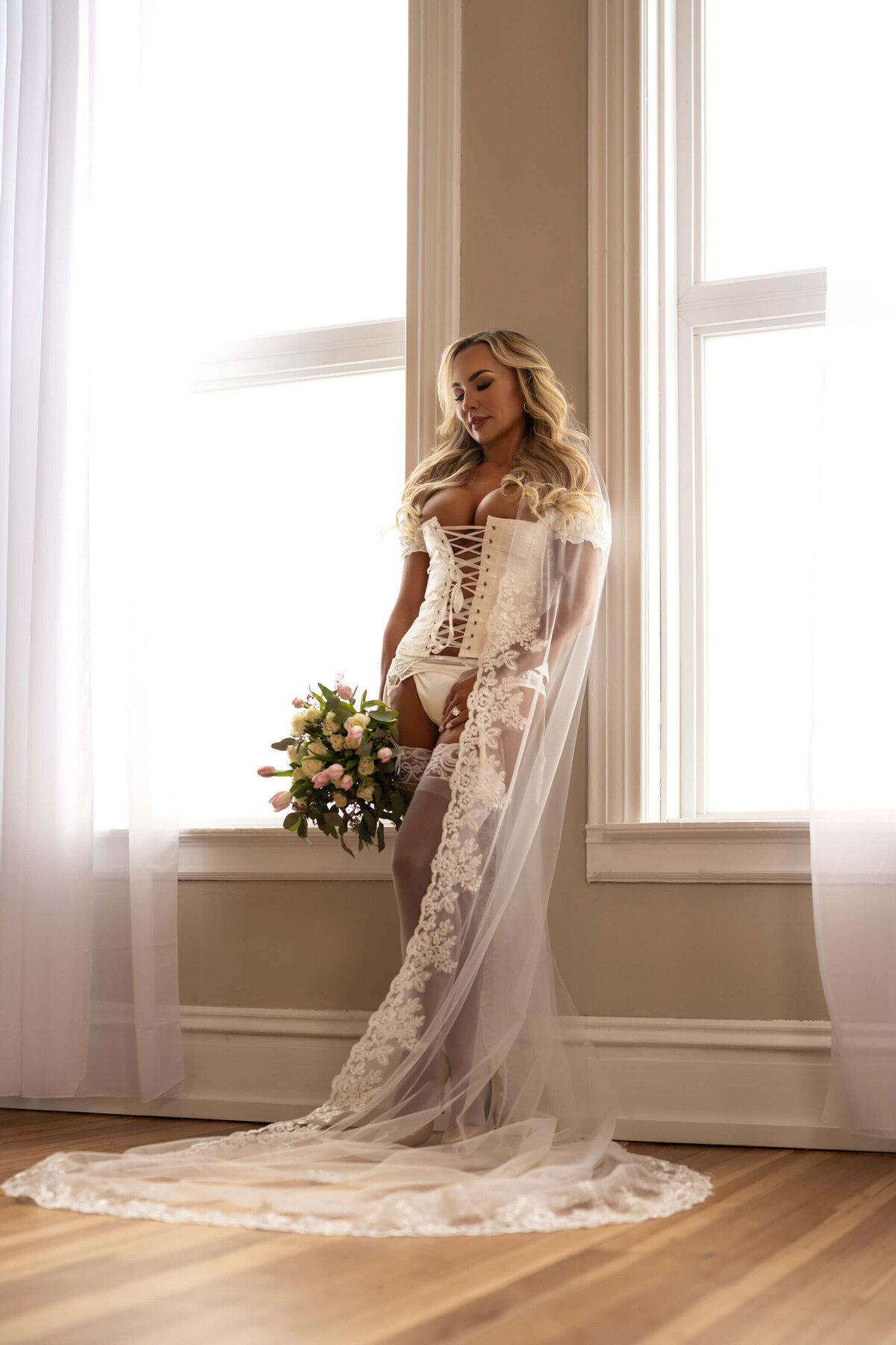 Romantic bridal boudoir session with soft veiled elegance.