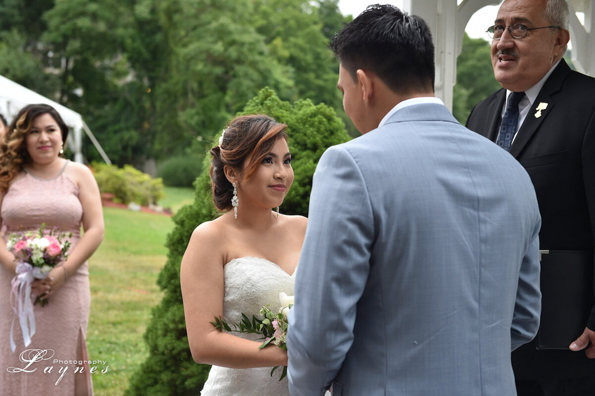 Bride and groom sharing a moment; soft glam bridal look with lashes and blush tones.