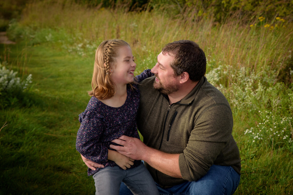 Father and daughter portrait in a long grassy field at Fonferek Glen County Park near Green Bay, Wisconsin.