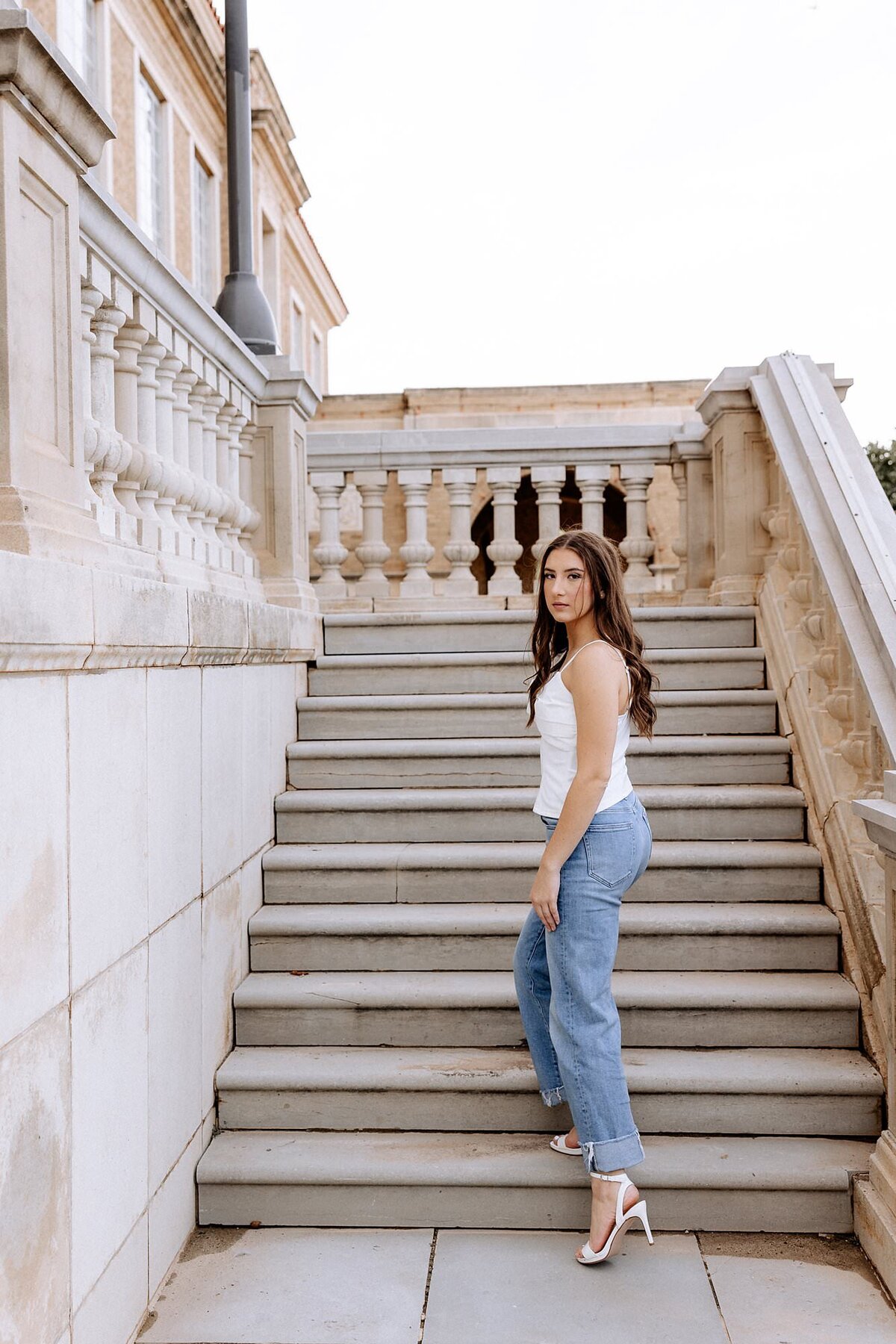 senior girl walking up the steps looking back at the camera. Photo captured by Mary Wiebe photography