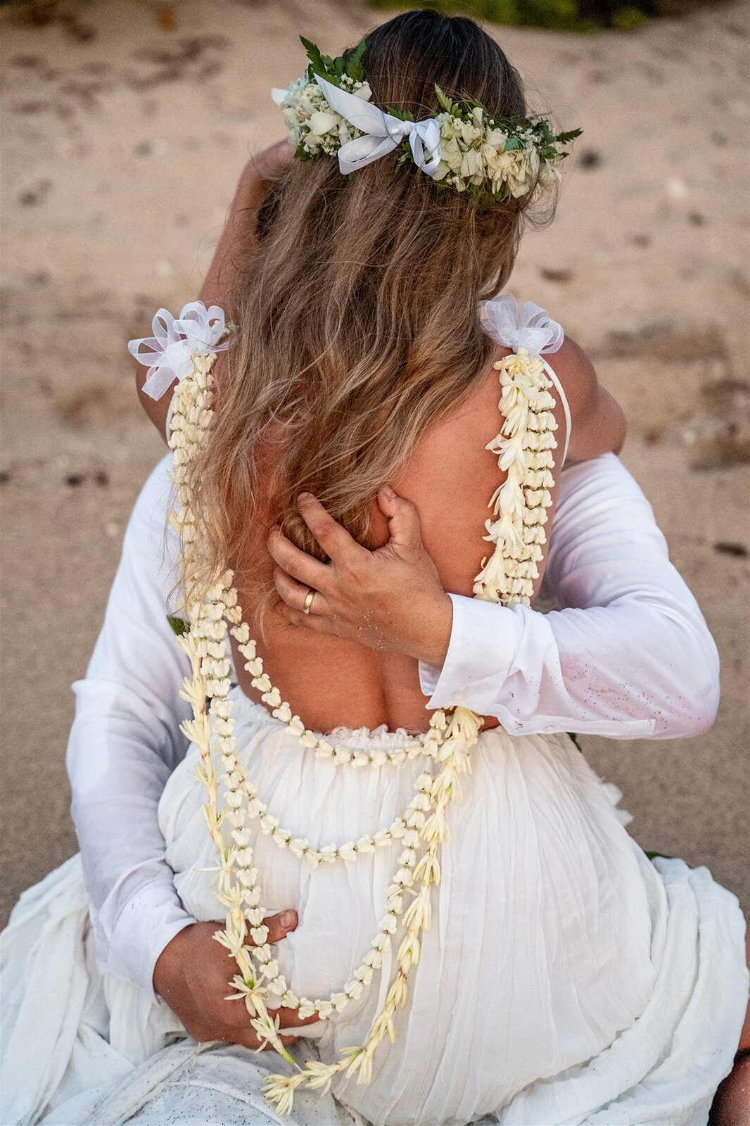 Bride and groom embracing on the beach taken by one of the best kona hawaii wedding photographers
