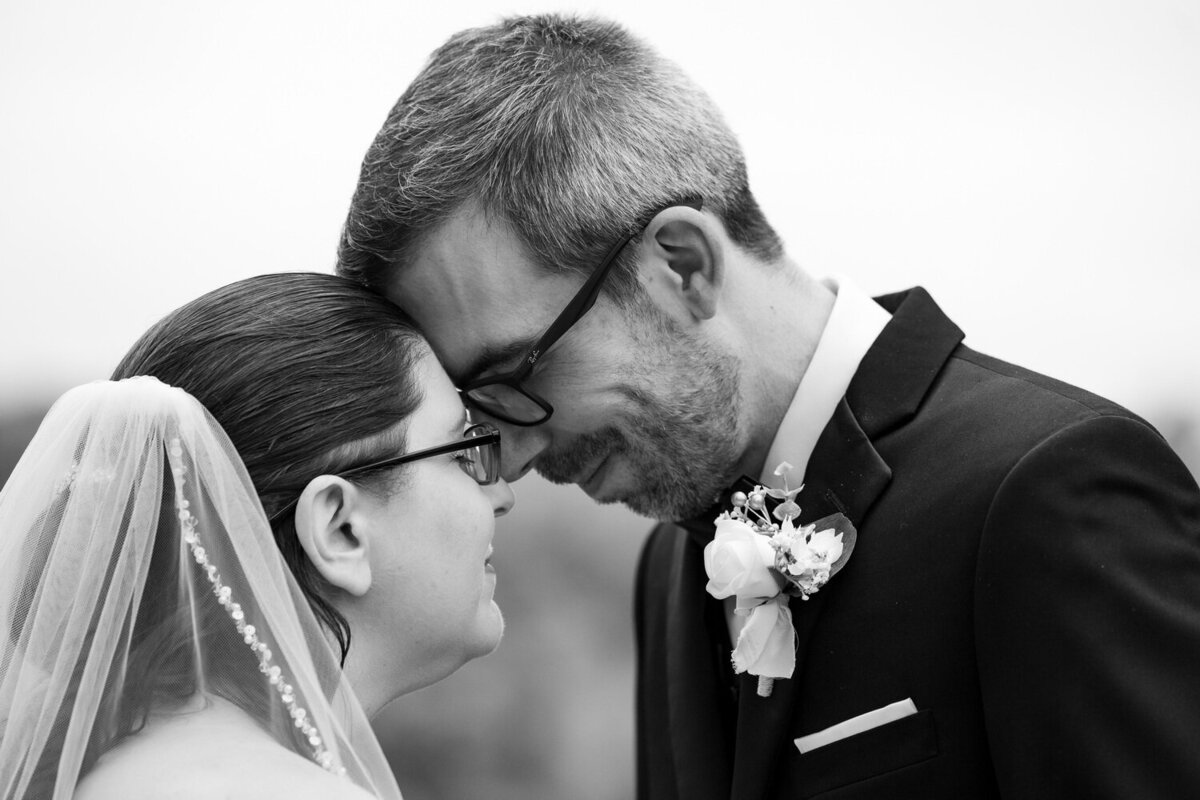 black and white closeup of a straight White couple leaning foreheads against each other intimately