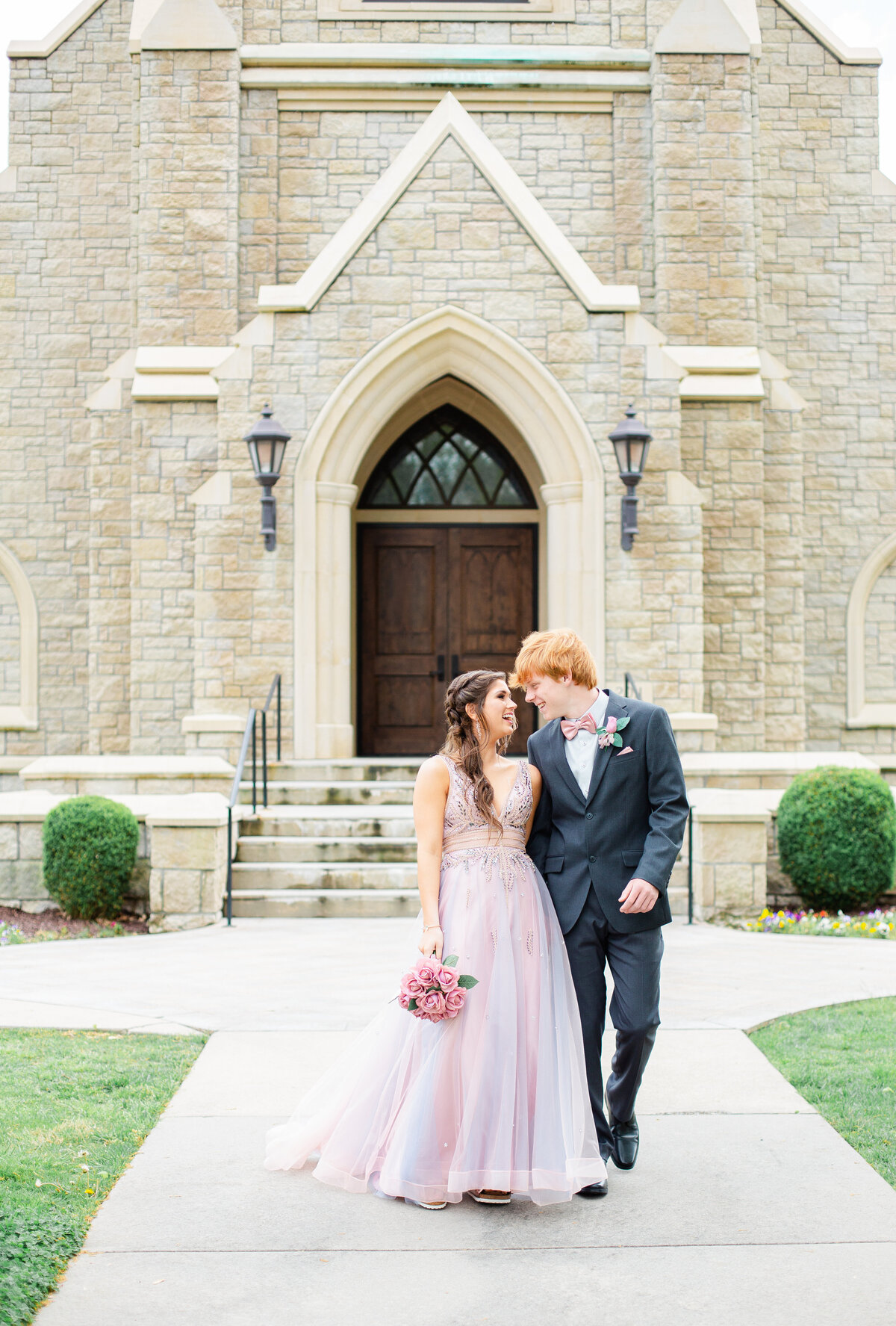prom couple walking together in front of the chapel at Lee University