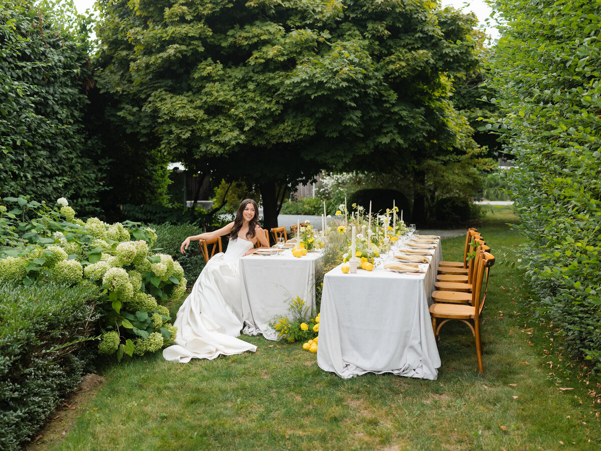 Bride and groom sit at their reception table as they watch speeches