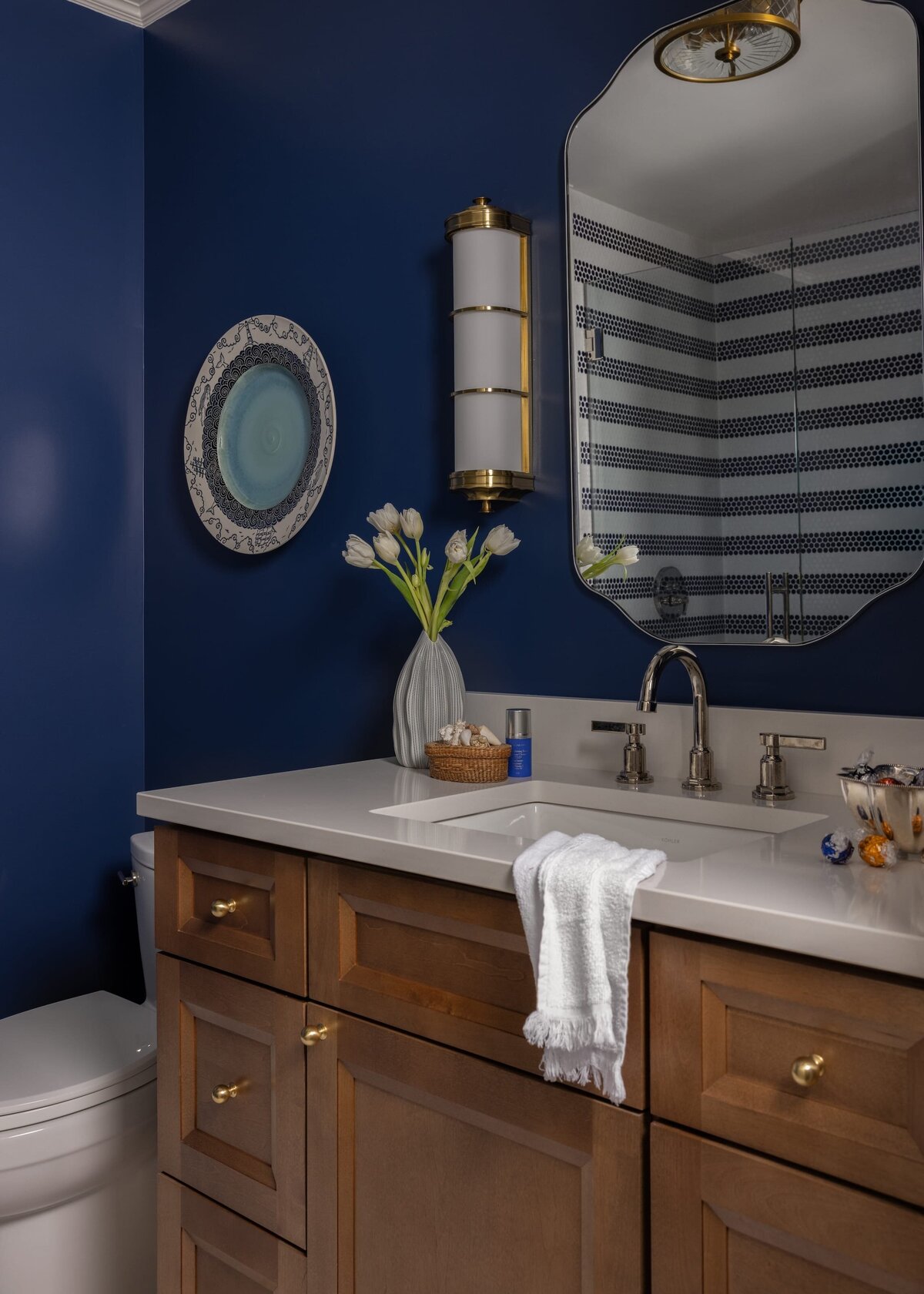 melinda chesson interiors poindexter bathroom with dark blue painted walls and wooden vanity