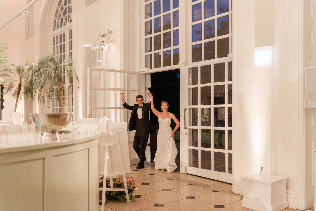 bride-and-groom-entering-orangery-wedding-reception-min