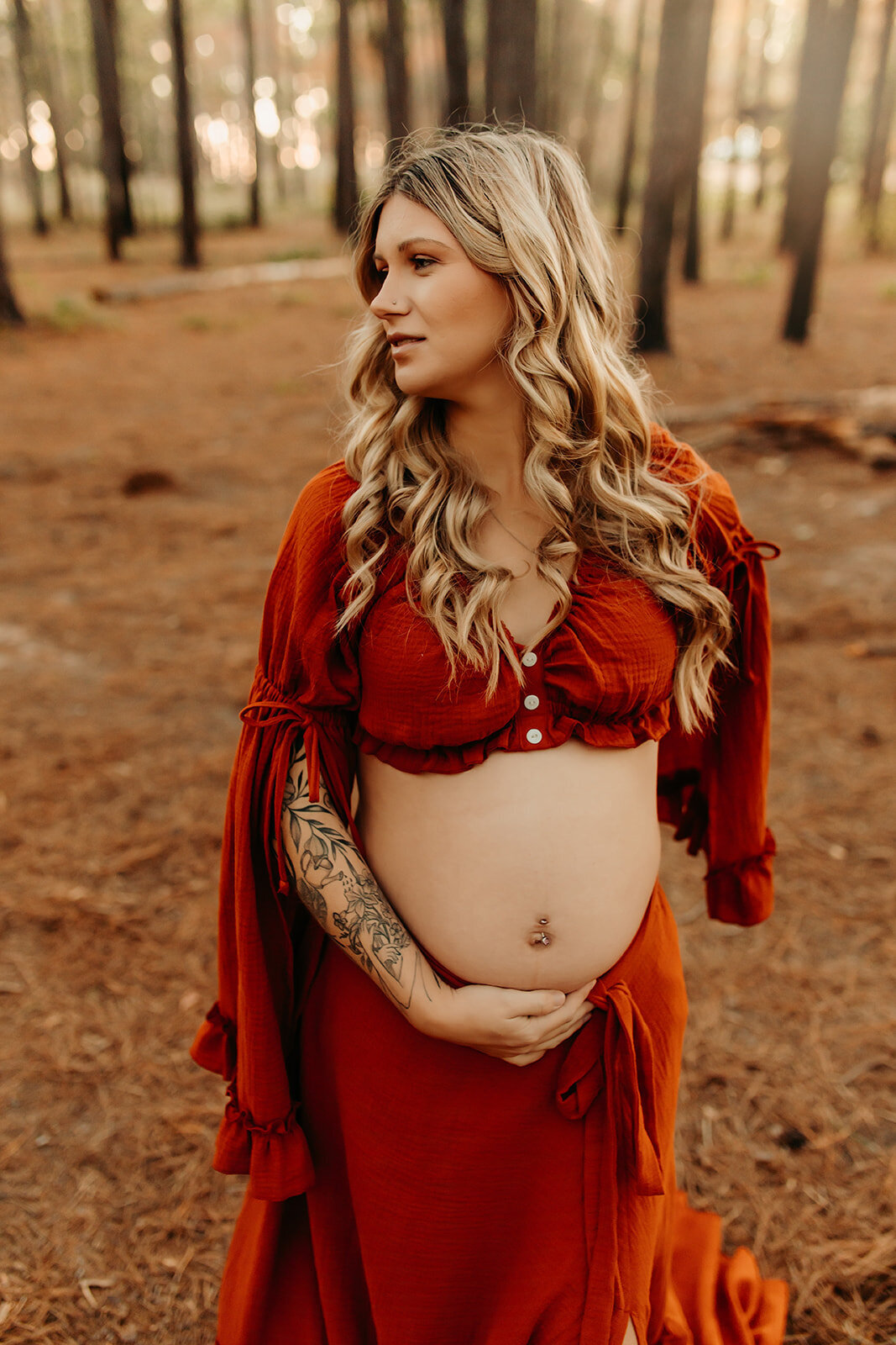 Solo maternity portrait in Hardin TX, expecting mother in burnt orange dress holding baby bump