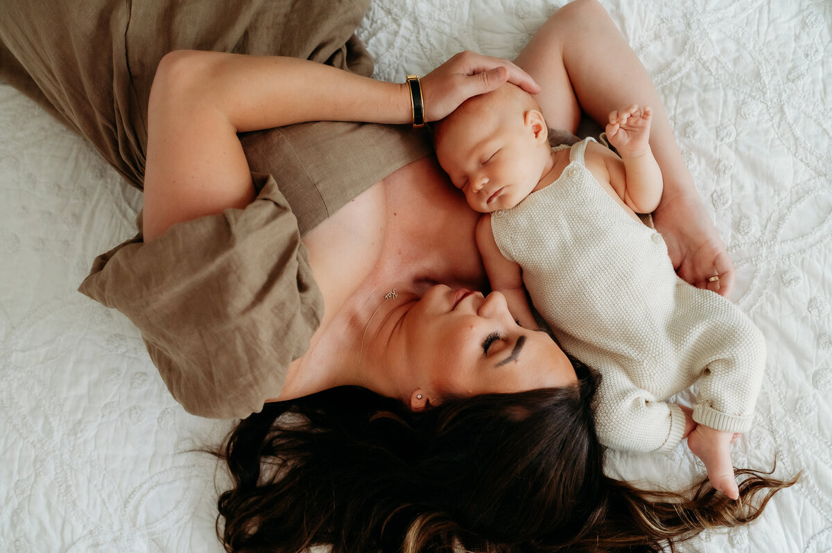mother holds baby in bed