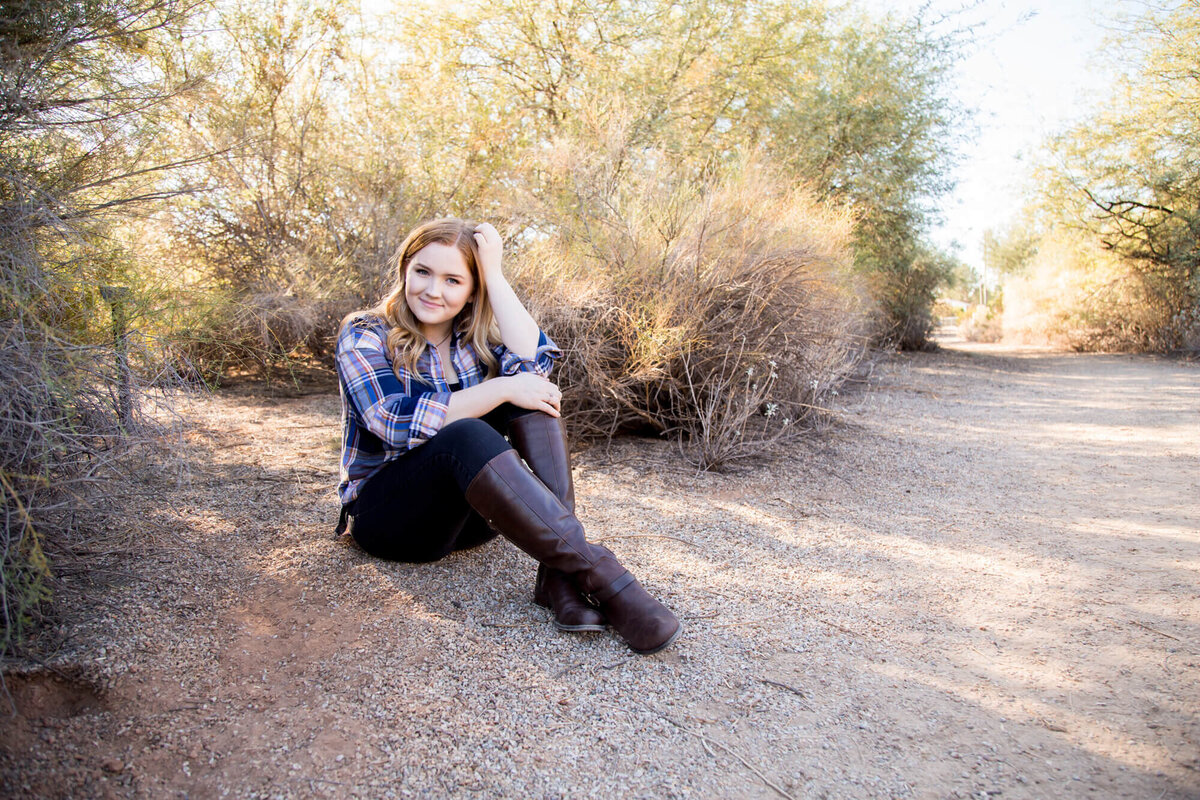 Redheaded senior girl sitting on a park path