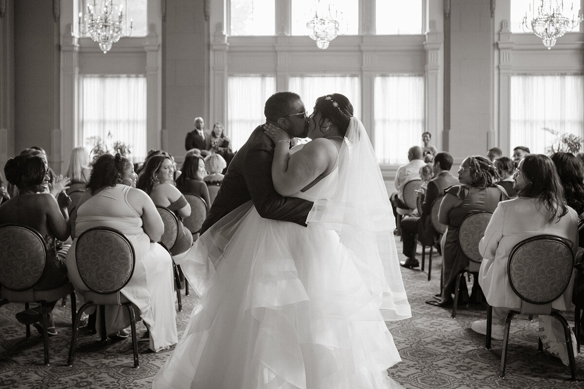 couple kisses at the end of the wedding aisle ceremony