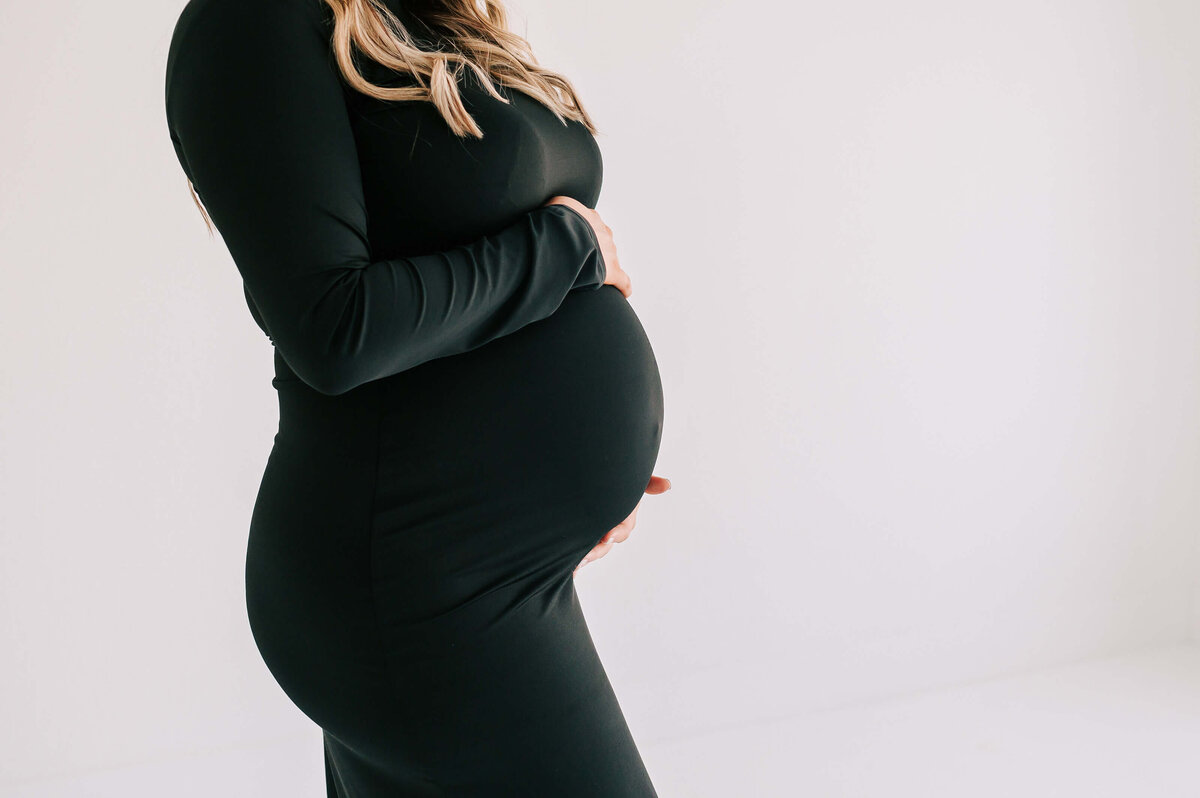 close up of baby bump in black dress