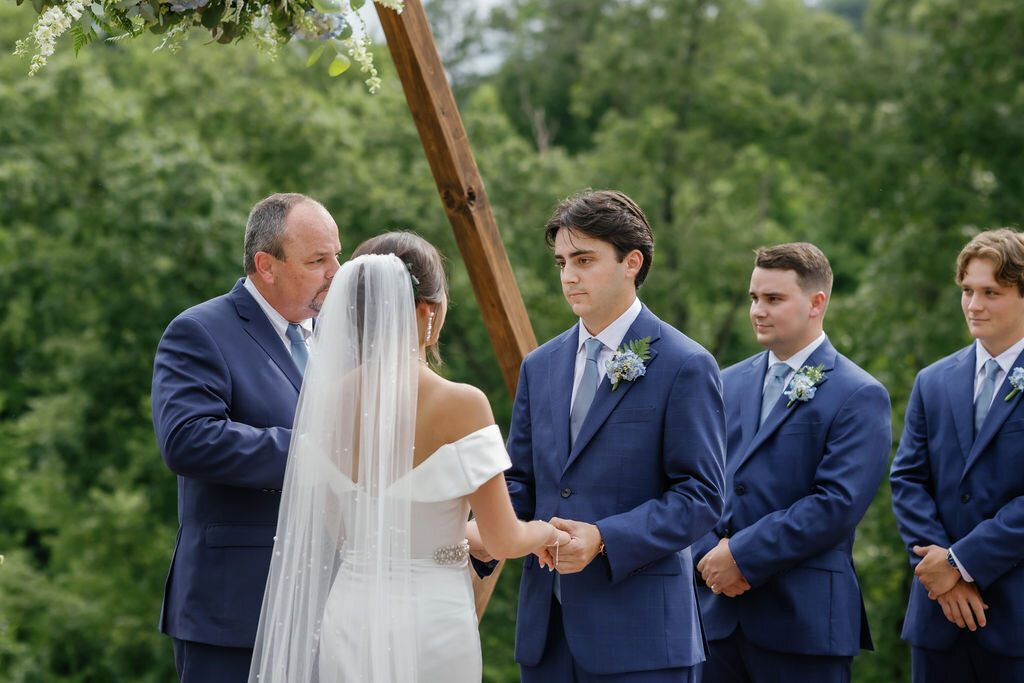 Mountain Mist wedding venue with groom holding his brides hands and smiling during their outdoor elopement in the mountains 