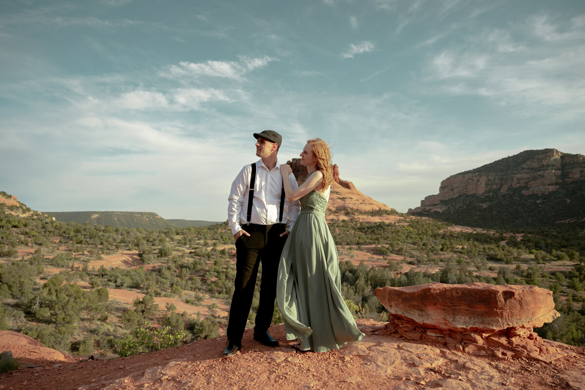 Couple standing against red rock backdrop during Sedona engagement session