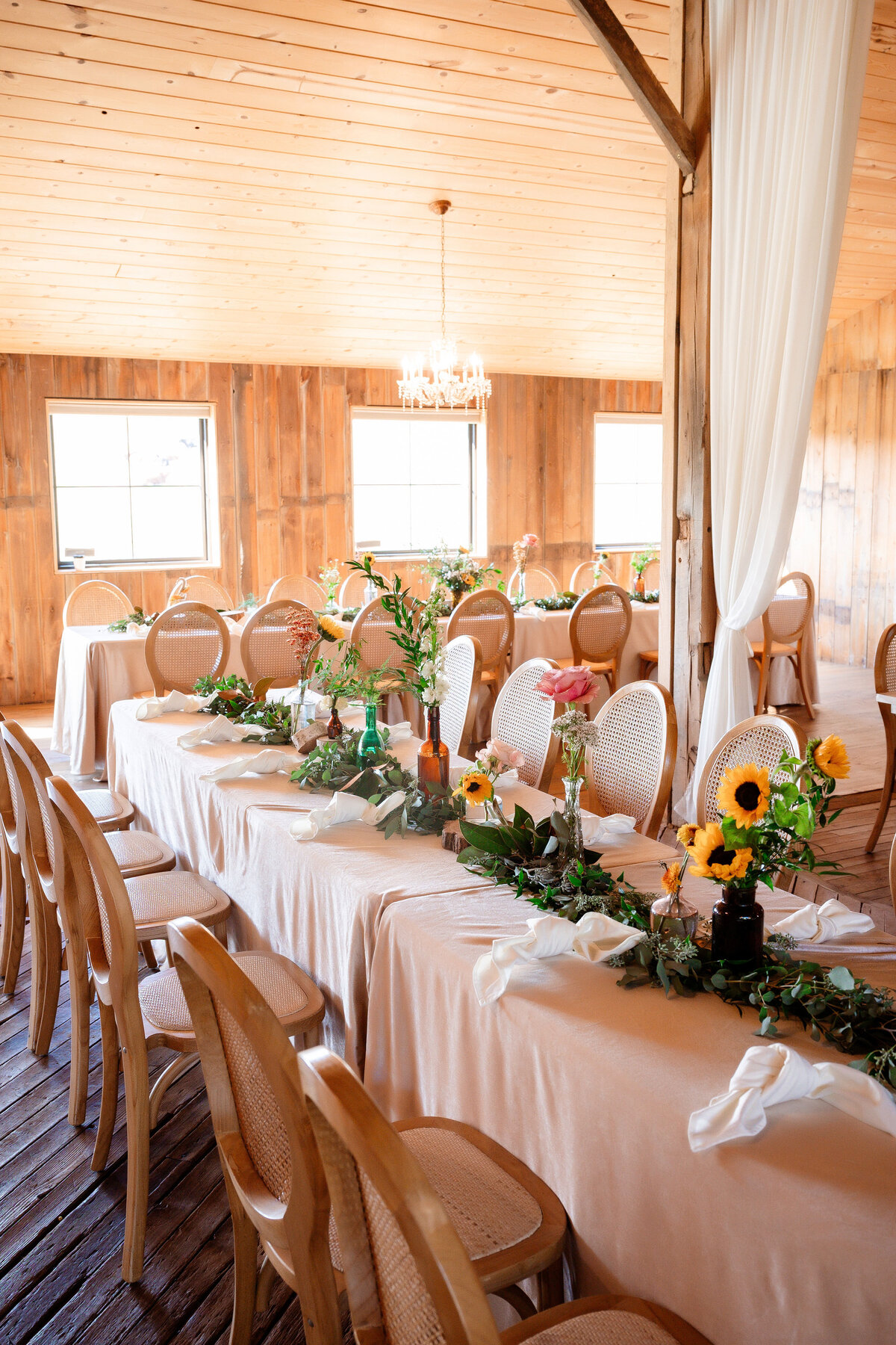 barn wedding with sunflowers and light cream colored linens