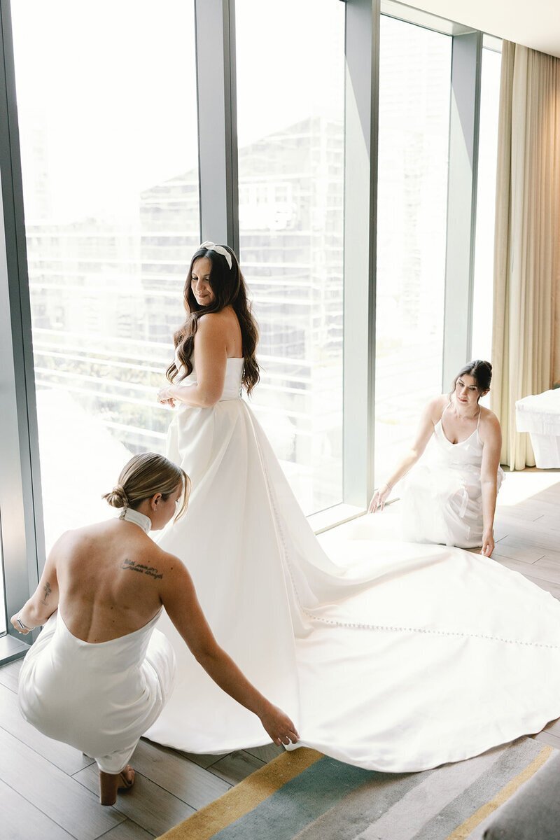 penthouse at riverside wharf photos of bridesmaids helping bride with dress