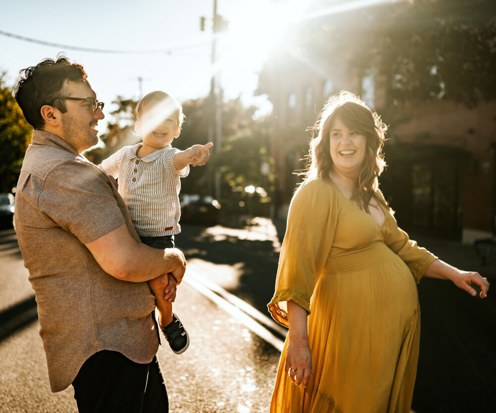 family of three crossing the street and smiling