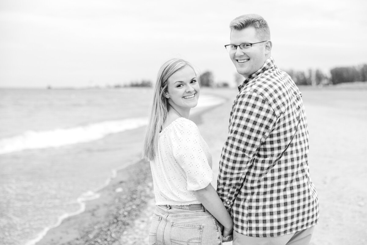 Light and airy beach engagement black and white photo along the shore at Mentor Headlands Beach