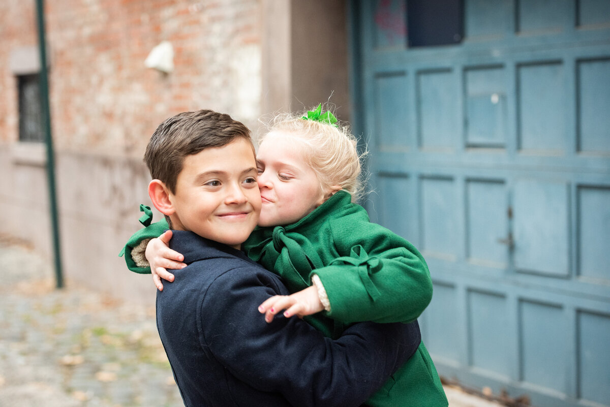 A child kissing their sibling's cheek