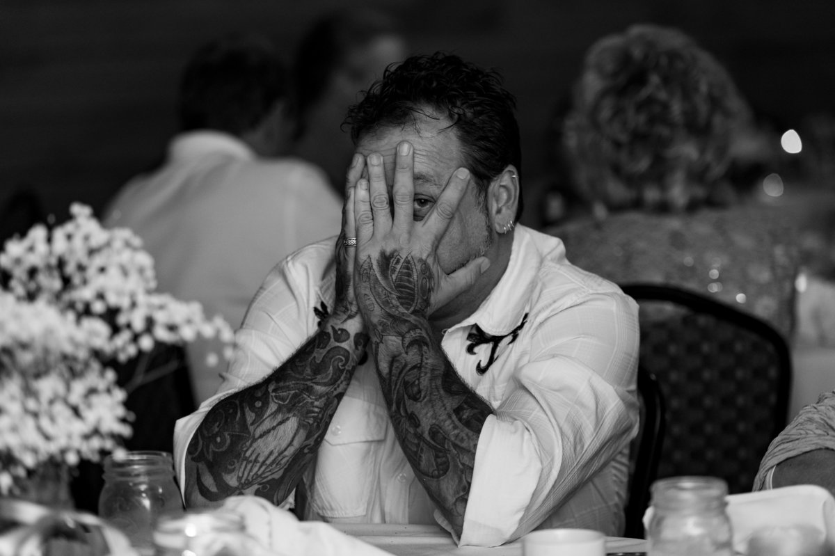 tattooed father of bride peeking through fingers