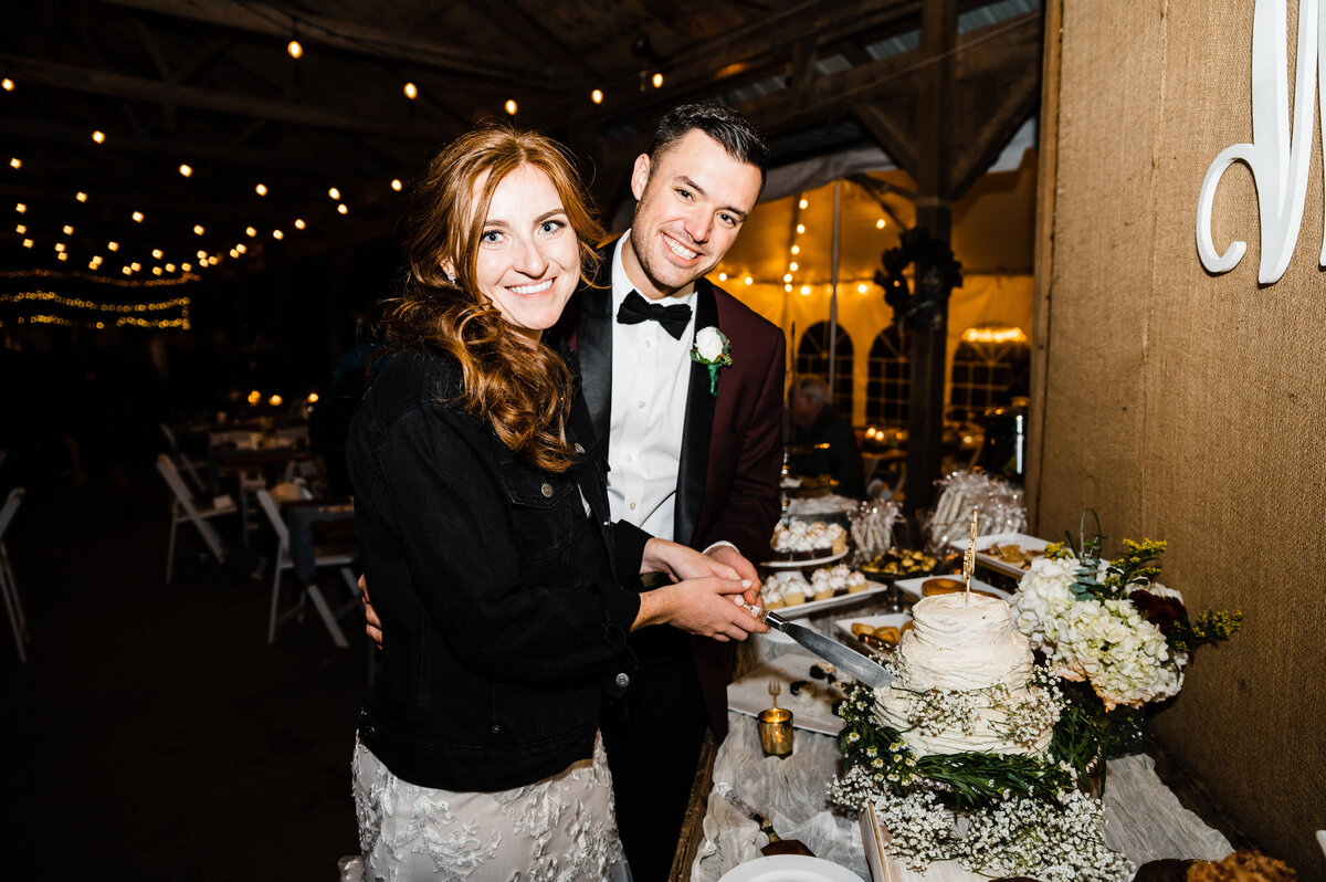 bride and groom cutting their wedding cake at their indoor reception at Murray Hill photographed by Charlottesville wedding photographer