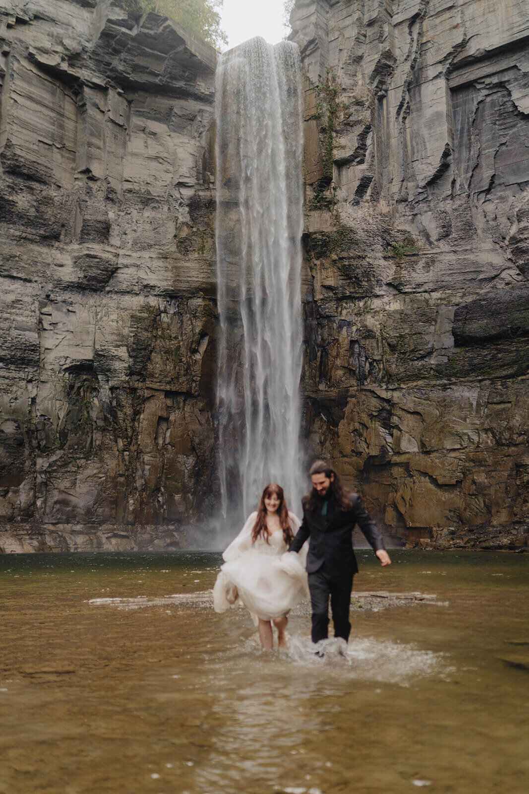 Bride and groom in front of waterfall at Finger Lakes wedding, NY