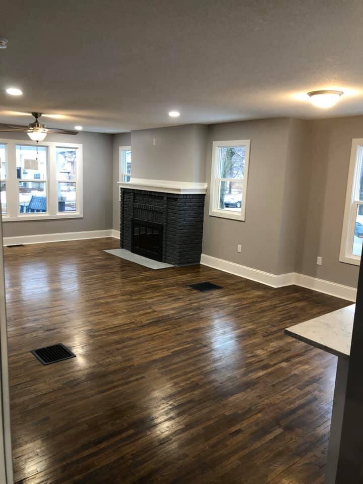 Remodeled living room with grey walls and dark hardwood floors