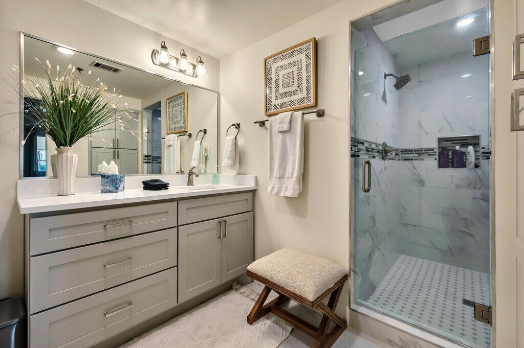 Bathroom with large vanity and shower in this 2 bedroom, 2.5 bathroom luxury vacation rental loft condo for 8 guests with incredible downtown views, free parking, free wifi and professional decor in downtown Waco, TX.