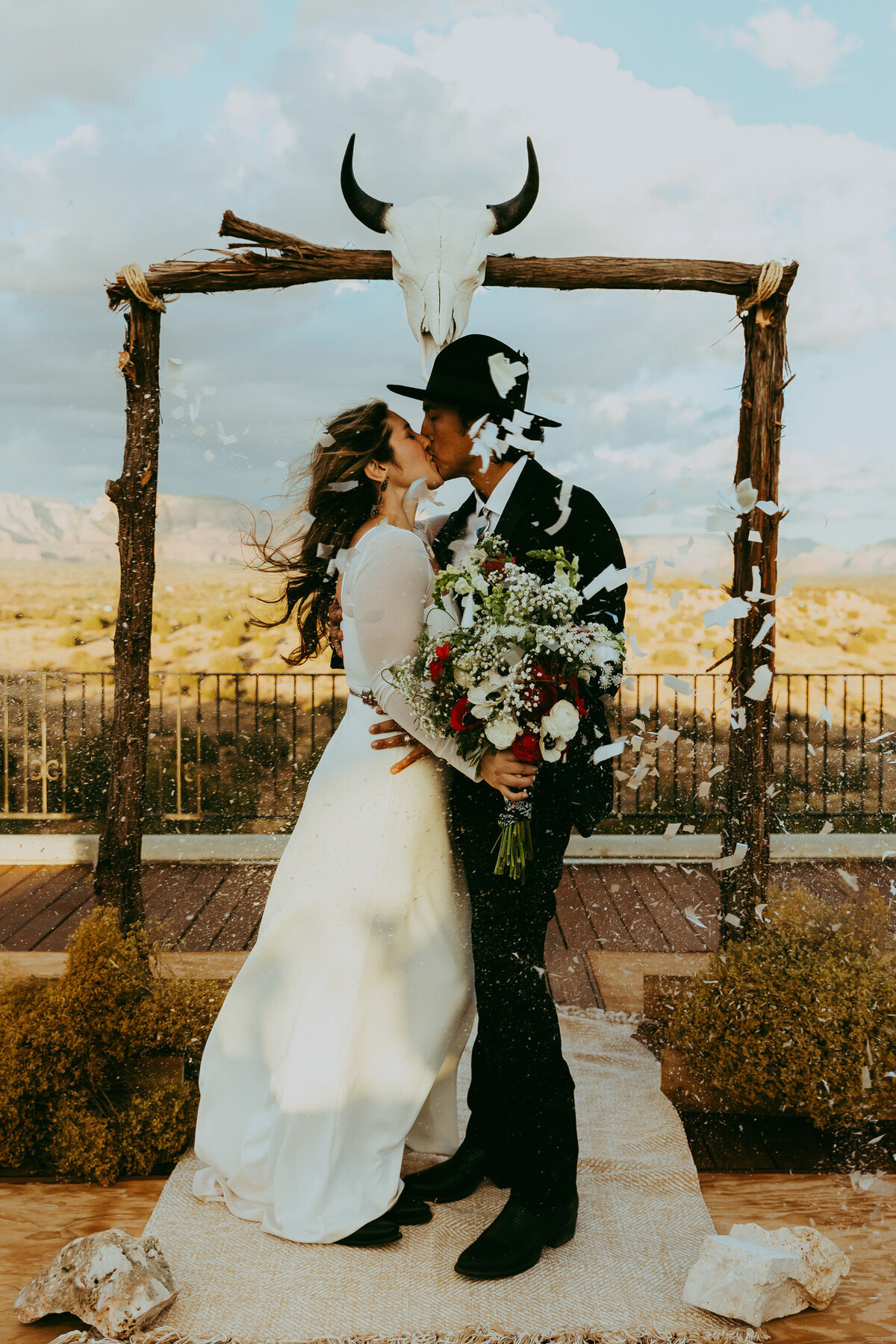 couple kisses as confetti pops in sedona wedding