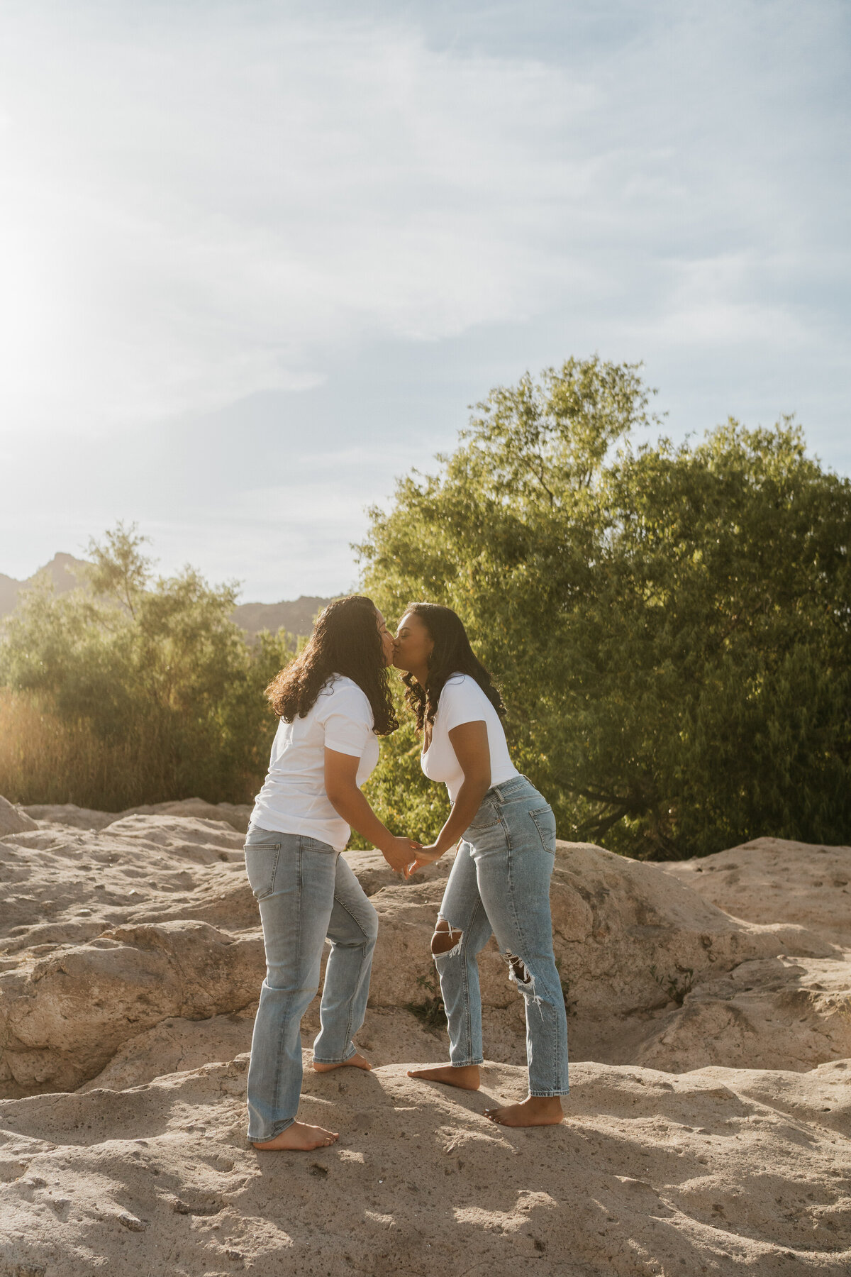 A couple kissing while standing on rocks 