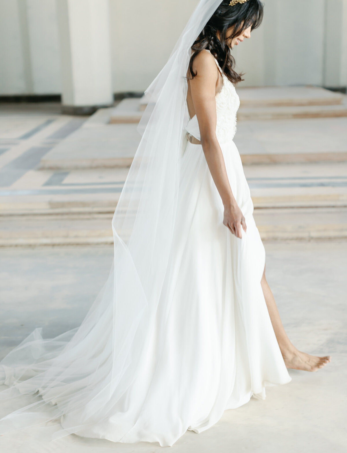barefoot bride in long white dress and veil in abandoned cathedral, ruins wedding venue in Europe