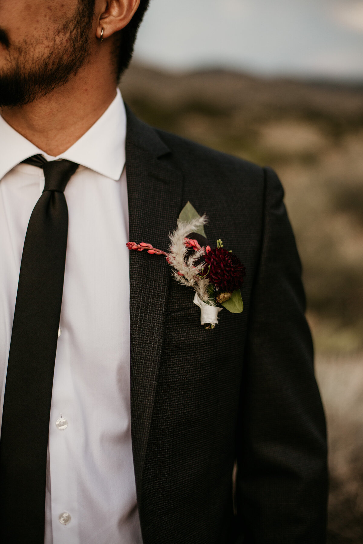 pink and putple groom boutonniere on coat
