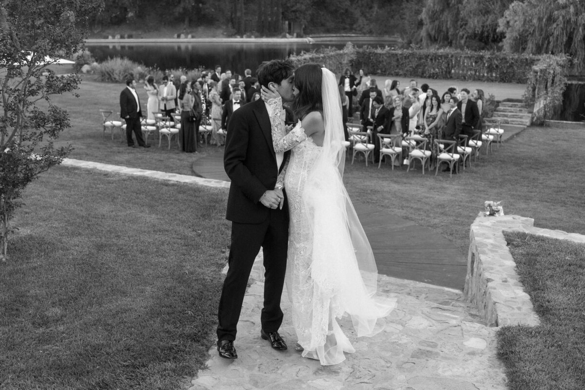couple kissing in front of their guests after ceremony 