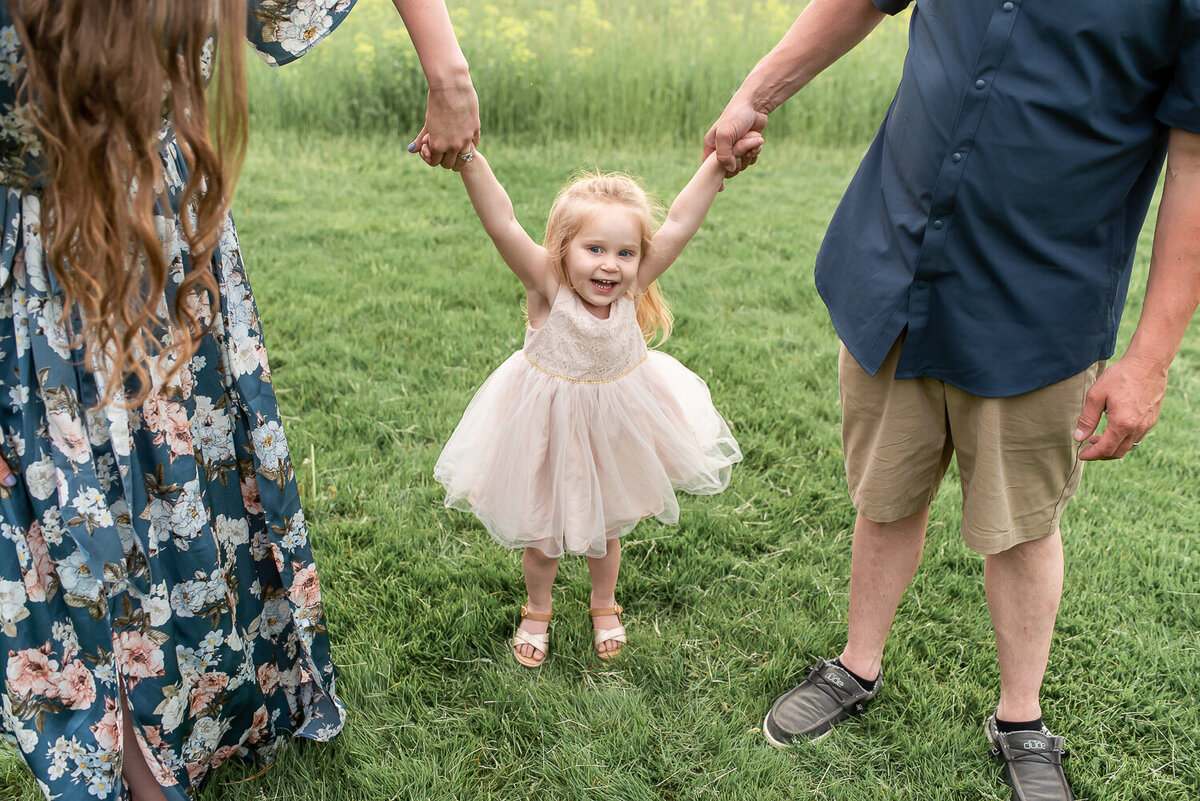 Girl swinging between her parents in field for family photo shoot |Sharon Leger Photography | Canton, CT Newborn & Family Photographer