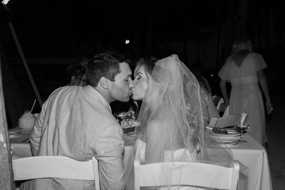 Monica and Austyn share a sweet kiss during their wedding reception dinner in the Florida Keys.