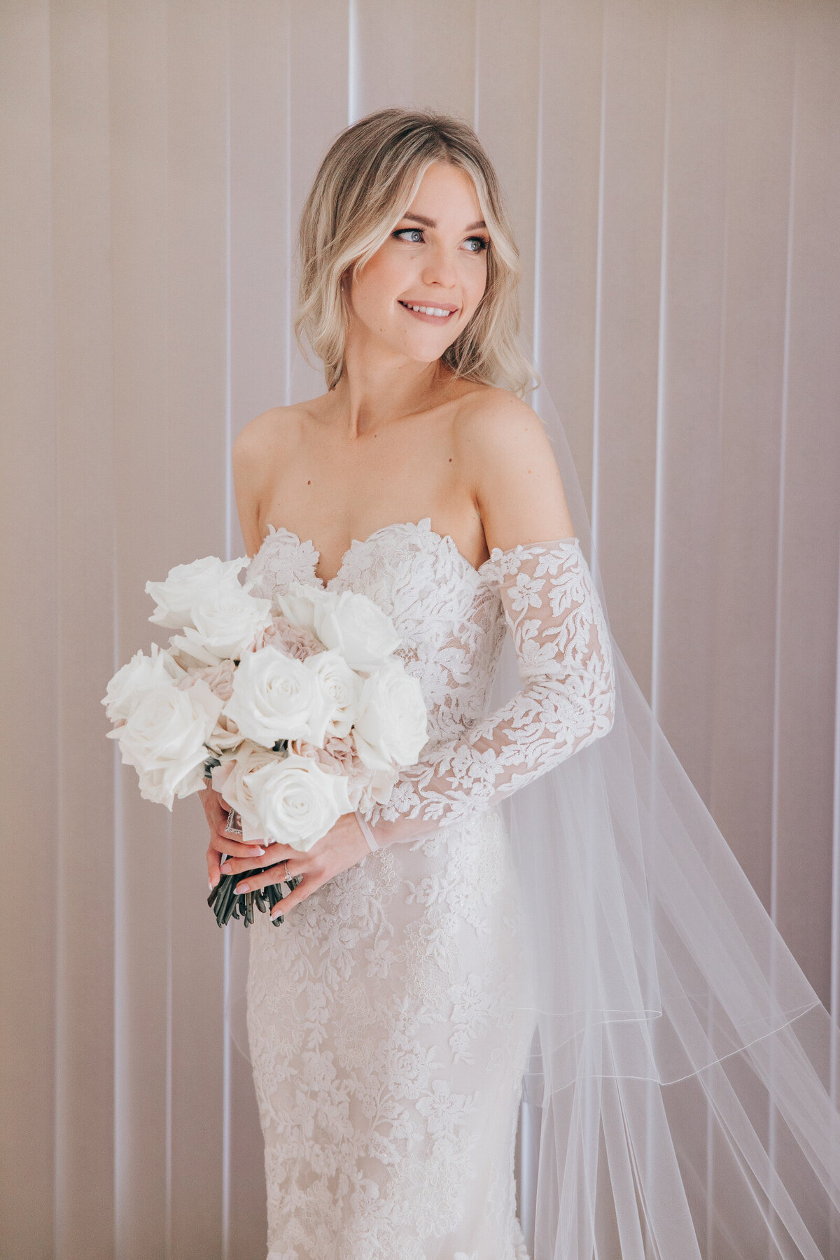 Luxurious bridal portraits of bride holding gorgeous bouquet of white and pink roses
